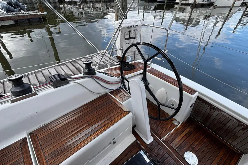 Respite Yacht Photos Pics 2014 Hanse 345 yacht cockpit with wooden deck and steering wheel at marina.