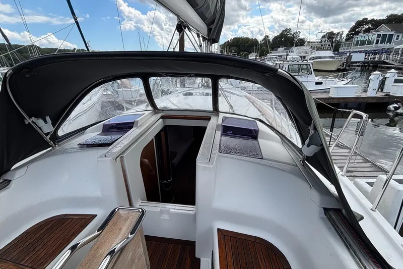 Respite Yacht Photos Pics 2014 Hanse 345 sailboat cockpit with canopy, docked at marina under cloudy sky.