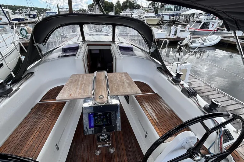 Respite Yacht Photos Pics 2014 Hanse 345 sailboat cockpit with wooden seating and steering wheel at marina.