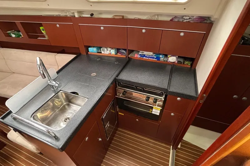 Respite Yacht Photos Pics 2014 Hanse 345 yacht kitchen with sink, stove, and wooden cabinetry.