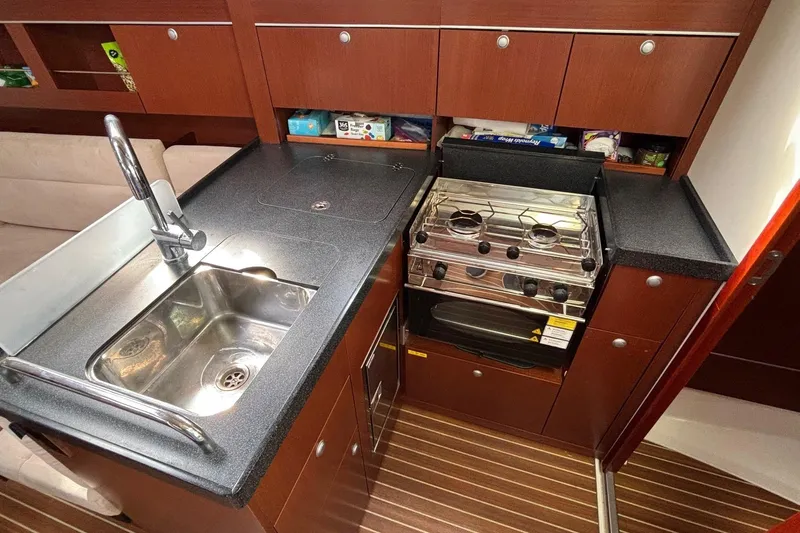 Respite Yacht Photos Pics 2014 Hanse 345 yacht kitchen with sink, stove, and wooden cabinetry.