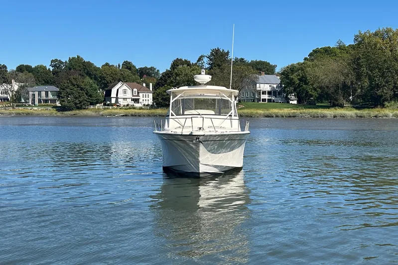  Yacht Photos Pics 2016 Grady-White Express 330 boat on calm water with houses in the background.