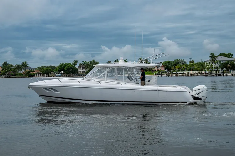  Yacht Photos Pics 2019 Intrepid 407 Cuddy cruising on a calm waterway under a cloudy sky.