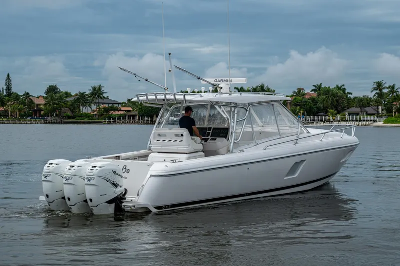  Yacht Photos Pics 2019 Intrepid 407 Cuddy boat cruising on a calm waterway with lush greenery.