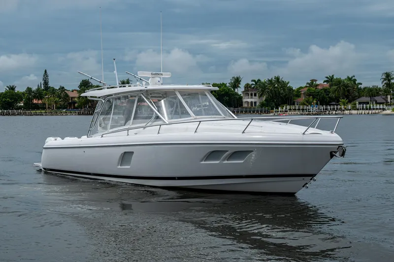  Yacht Photos Pics 2019 Intrepid 407 Cuddy boat on calm water, with a cloudy sky backdrop.