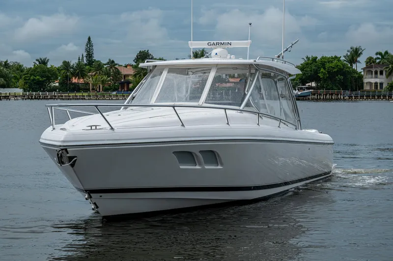  Yacht Photos Pics 2019 Intrepid 407 Cuddy boat cruising on a calm waterway under cloudy skies.