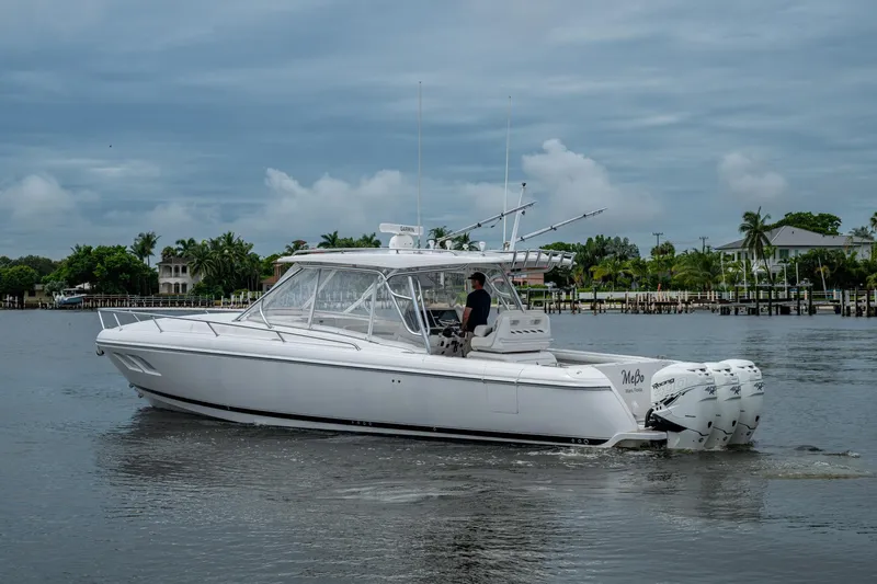  Yacht Photos Pics 2019 Intrepid 407 Cuddy boat cruising on a calm waterway under cloudy skies.