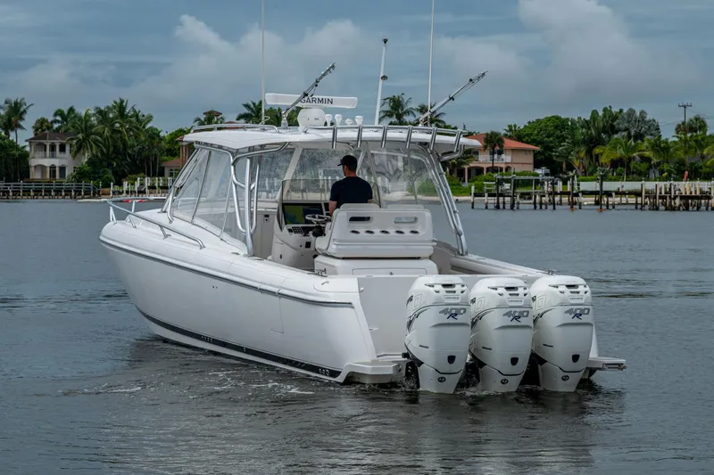  Yacht Photos Pics 2019 Intrepid 407 Cuddy boat with triple outboard engines on calm water.