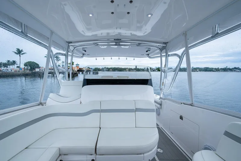  Yacht Photos Pics Interior view of 2019 Intrepid 407 Cuddy boat with white seating and waterfront backdrop.