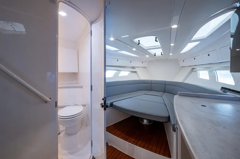  Yacht Photos Pics 2019 Intrepid 407 Cuddy interior with seating, skylights, and compact bathroom.