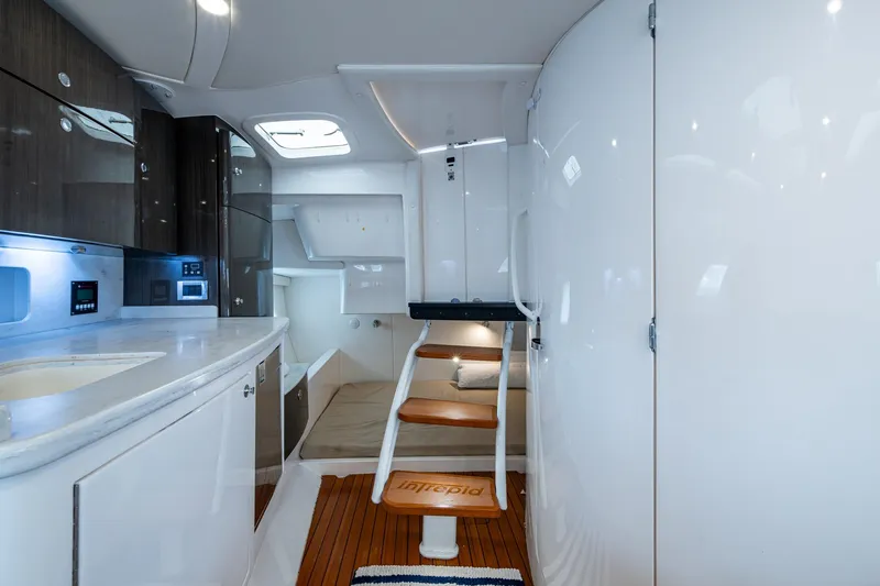  Yacht Photos Pics Luxurious interior of 2019 Intrepid 407 Cuddy boat with modern kitchen and wooden steps.