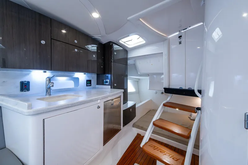  Yacht Photos Pics Luxurious interior of 2019 Intrepid 407 Cuddy boat with modern kitchen and cozy seating.