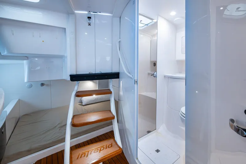 Yacht Photos Pics 2019 Intrepid 407 Cuddy interior with wooden steps, bed, and bathroom.