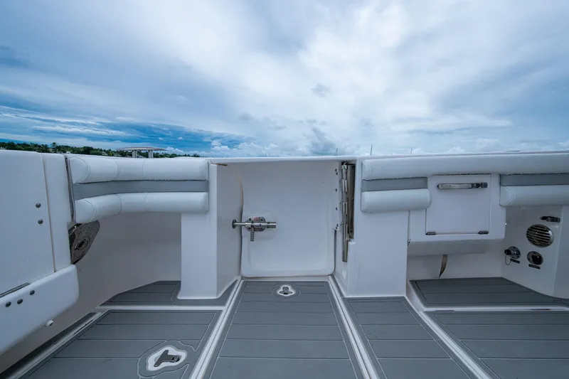  Yacht Photos Pics 2019 Intrepid 407 Cuddy boat deck with seating and storage under a cloudy sky.
