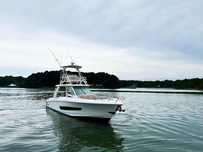 Seas The Day Yacht Photos Pics 2017 Boston Whaler 420 Outrage boat on calm water, overcast sky.