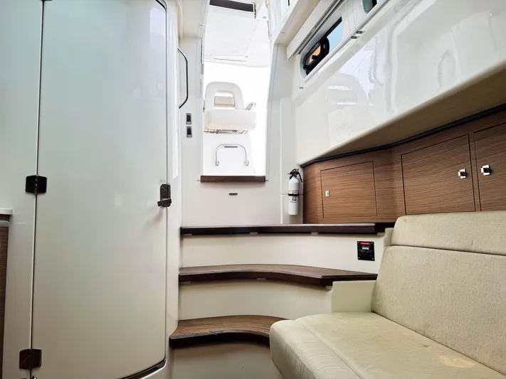 Seas The Day Yacht Photos Pics 2017 Boston Whaler 420 Outrage interior with stairs, seating, and wooden cabinetry.