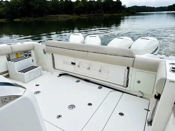 Seas The Day Yacht Photos Pics 2017 Boston Whaler 420 Outrage boat interior with seating and outboard motors on a calm lake.