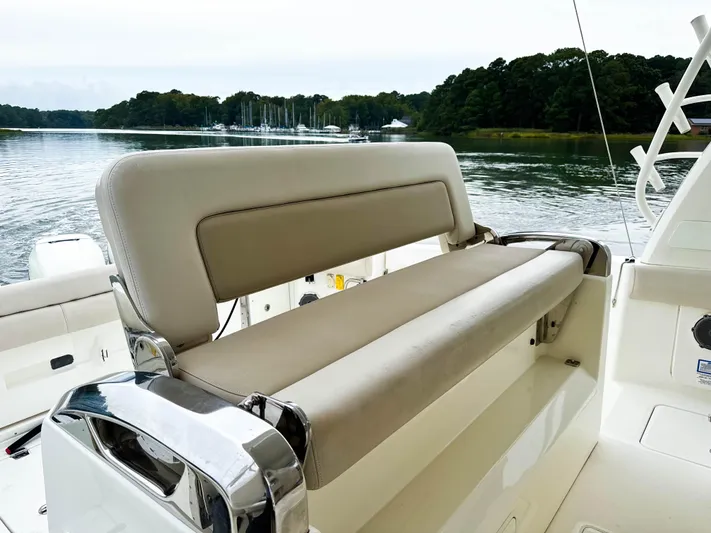Seas The Day Yacht Photos Pics 2017 Boston Whaler 420 Outrage boat interior with cushioned seating, docked by a serene lake.