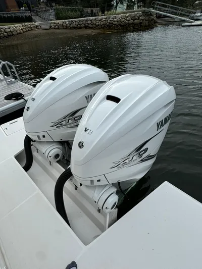 Harley Quinn Yacht Photos Pics Twin Yamaha outboard engines on a 2023 Regal 36 XO boat, docked by the water.