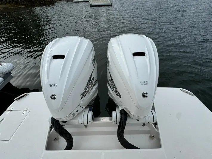 Harley Quinn Yacht Photos Pics Twin V8 engines on a 2023 Regal 36 XO boat, docked on calm water.