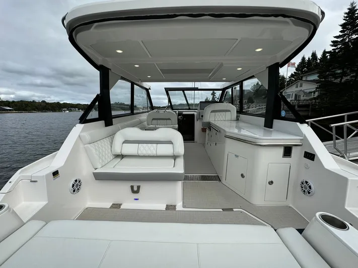 Harley Quinn Yacht Photos Pics 2023 Regal 36 XO yacht interior with spacious seating and modern design on a serene waterfront.