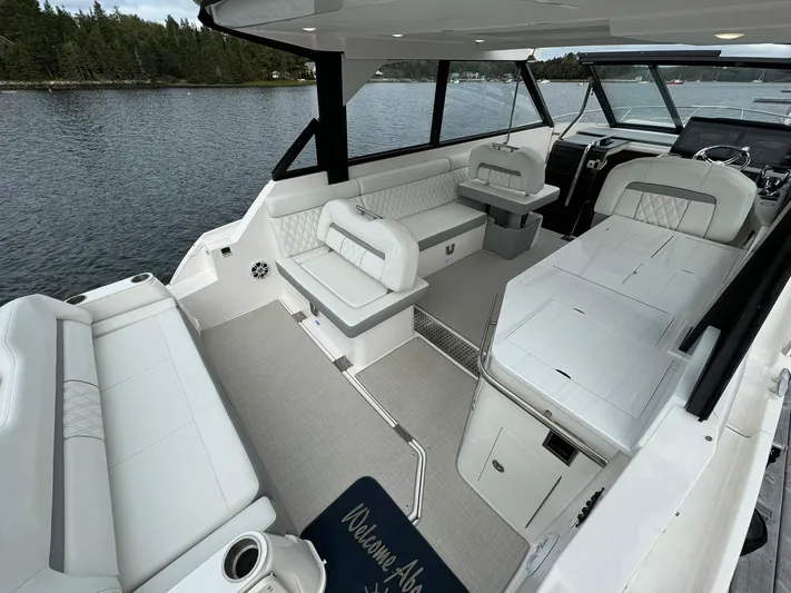 Harley Quinn Yacht Photos Pics 2023 Regal 36 XO boat interior with white seating and scenic water view.