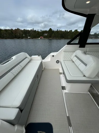 Harley Quinn Yacht Photos Pics 2023 Regal 36 XO boat interior with white seating, overlooking a serene lake.
