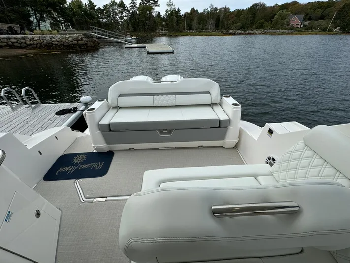 Harley Quinn Yacht Photos Pics 2023 Regal 36 XO boat interior with luxurious seating by the water.