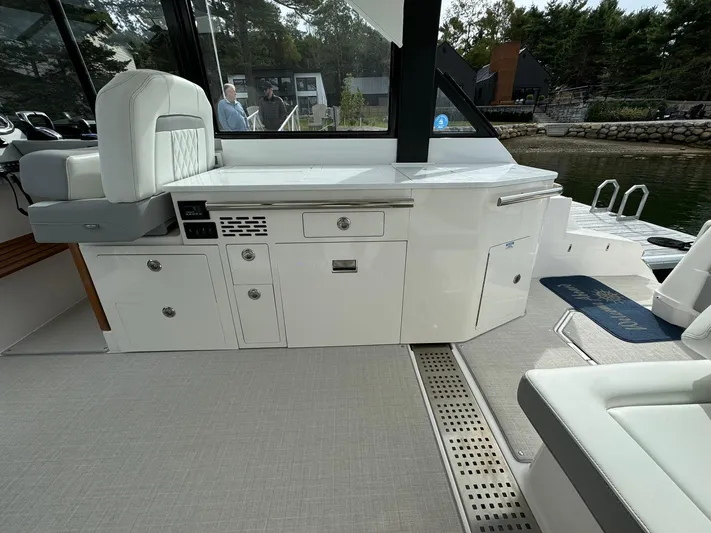 Harley Quinn Yacht Photos Pics 2023 Regal 36 XO yacht interior with sleek white cabinetry and seating.