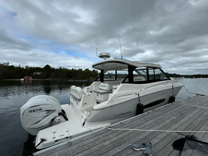 Harley Quinn Yacht Photos Pics 2023 Regal 36 XO boat docked, featuring Yamaha outboard motor, under cloudy sky.