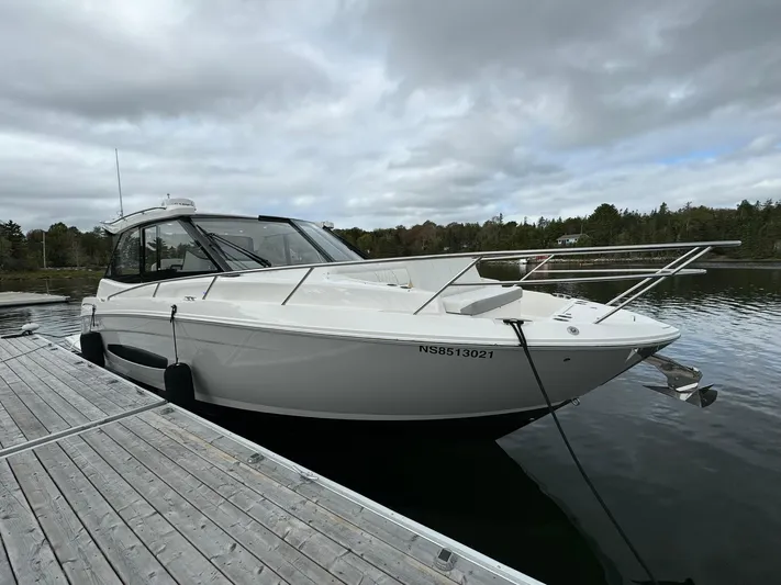 Harley Quinn Yacht Photos Pics 2023 Regal 36 XO boat docked on a calm lake under cloudy skies.