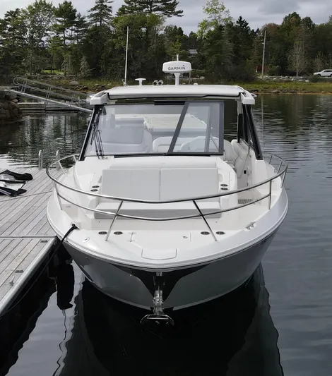 Harley Quinn Yacht Photos Pics 2023 Regal 36 XO boat docked on calm water, surrounded by trees.