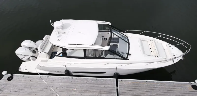 Harley Quinn Yacht Photos Pics 2023 Regal 36 XO boat docked, aerial view, sleek white design, dual outboard engines.