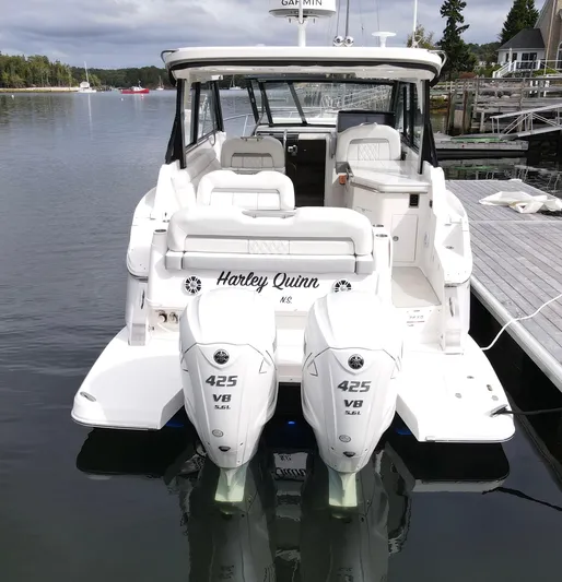 Harley Quinn Yacht Photos Pics 2023 Regal 36 XO boat with twin 425 V8 engines docked in a serene marina.