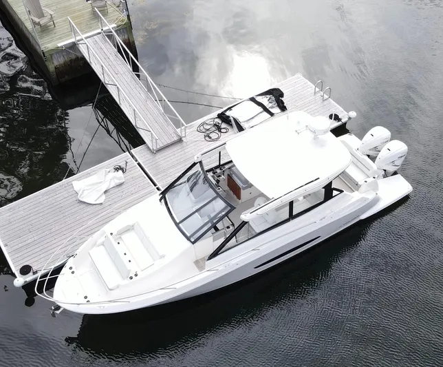 Harley Quinn Yacht Photos Pics 2023 Regal 36 XO boat docked on calm water, aerial view.