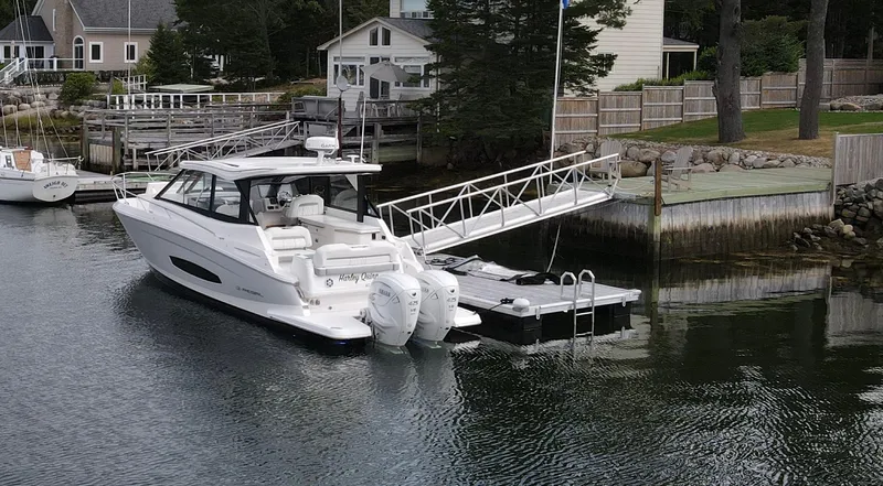 Harley Quinn Yacht Photos Pics 2023 Regal 36 XO boat docked in a serene waterfront setting.