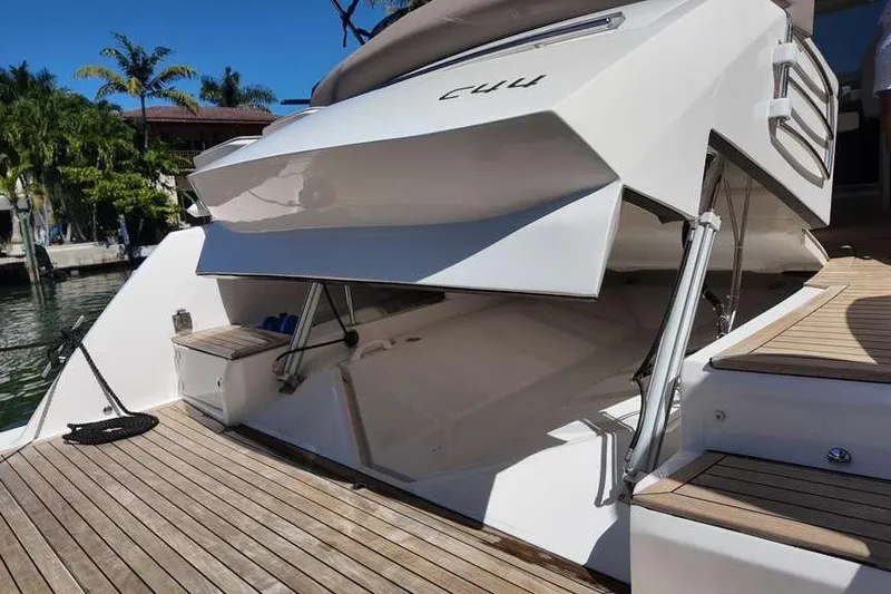  Yacht Photos Pics 2024 Sessa Marine C44 Cruiser with open deck hatch, docked by palm trees.