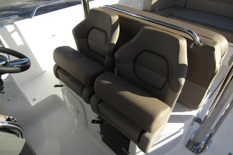  Yacht Photos Pics 2025 Nimbus Tender 9 boat interior with dual cushioned seats and steering wheel.