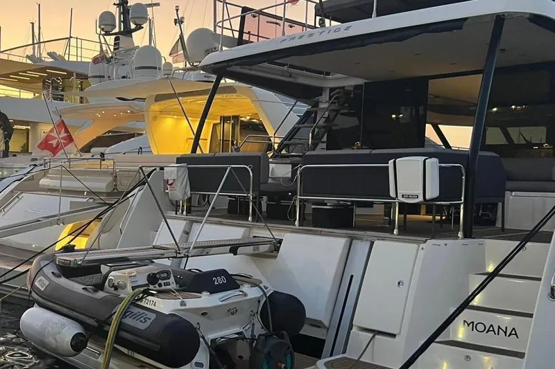 Moana Yacht Photos Pics 2024 Prestige M48 yacht docked at sunset with inflatable boat attached.