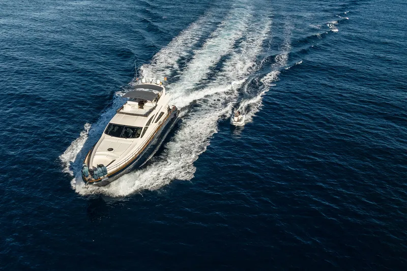 Mr Corn Yacht Photos Pics Luxurious 2010 Rodman Muse 74 yacht cruising with a small boat on open sea.