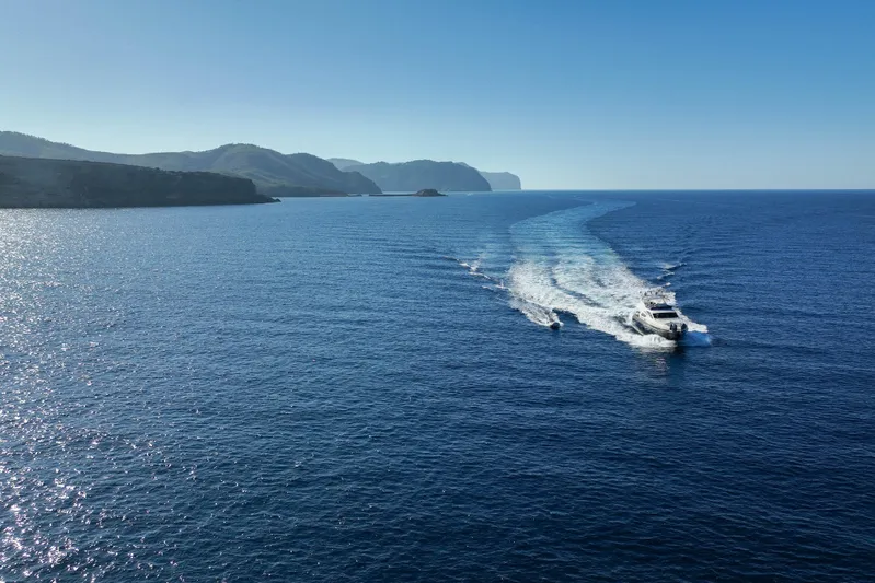 Mr Corn Yacht Photos Pics Rodman Muse 74 yacht cruising on open sea, 2010 model, with scenic coastal backdrop.
