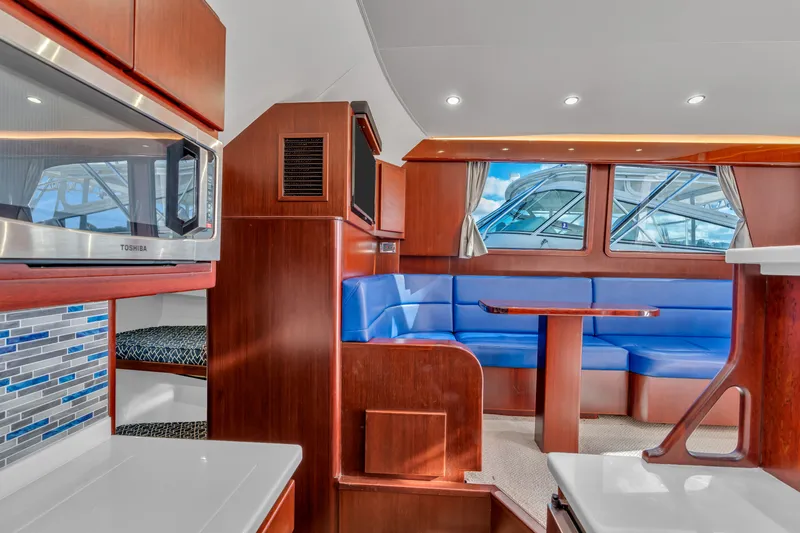 Sligo Yacht Photos Pics 2023 Henriques 42 Convertible yacht interior with blue seating, wood finishes, and modern kitchen.