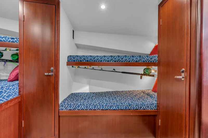 Sligo Yacht Photos Pics 2023 Henriques 42 Convertible interior with wooden cabinets and blue-patterned bunk beds.