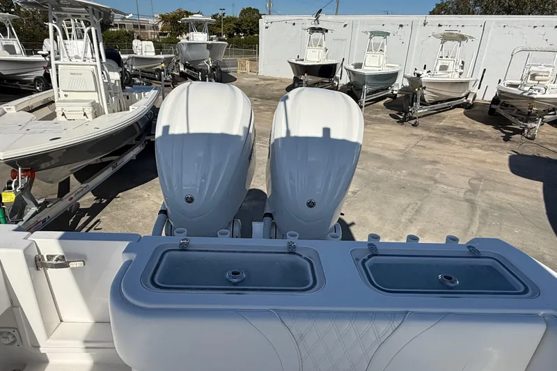  Yacht Photos Pics 2024 Contender 30 ST boat with dual engines, docked among other boats.