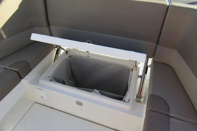  Yacht Photos Pics 2025 Nimbus Tender 9 boat storage compartment with open lid and cushioned seating.