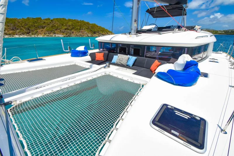 Rapscallion Yacht Photos Pics 2018 Lagoon 450 F catamaran with spacious deck, colorful cushions, and scenic ocean view.