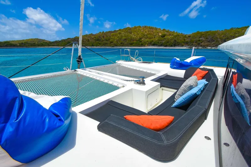 Rapscallion Yacht Photos Pics Luxurious Lagoon 450 F catamaran deck with colorful cushions, anchored in a serene tropical bay.