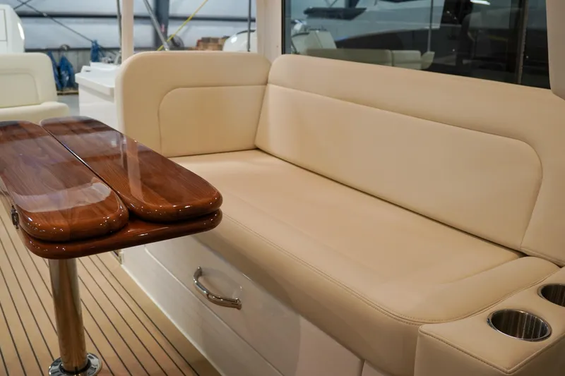 In Stock Yacht Photos Pics Luxurious seating area on 2025 MJM 35 yacht with wooden table and cup holders.