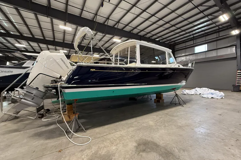 In Stock Yacht Photos Pics 2025 MJM 35 boat in a warehouse, featuring a sleek design and powerful outboard motor.