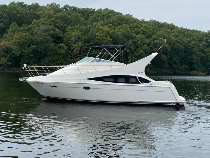  Yacht Photos Pics 2006 Carver 36 Mariner yacht on a calm lake with forested background.